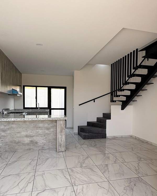 Escalera con barandal metálico y doble altura